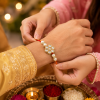 ACCESSHER Handmade White Floral Kundan Rakhi with Beads - Gift Set with Roli, Kumkum & Greeting Card
