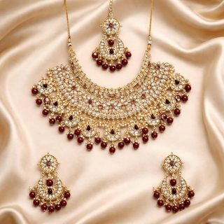 ACCESSHER Gold Plated Traditional Kundan and Ruby Stones Embellished Statement Bridal Necklace Jewellery Set with Pair of Earrings and Maang Tika for Women